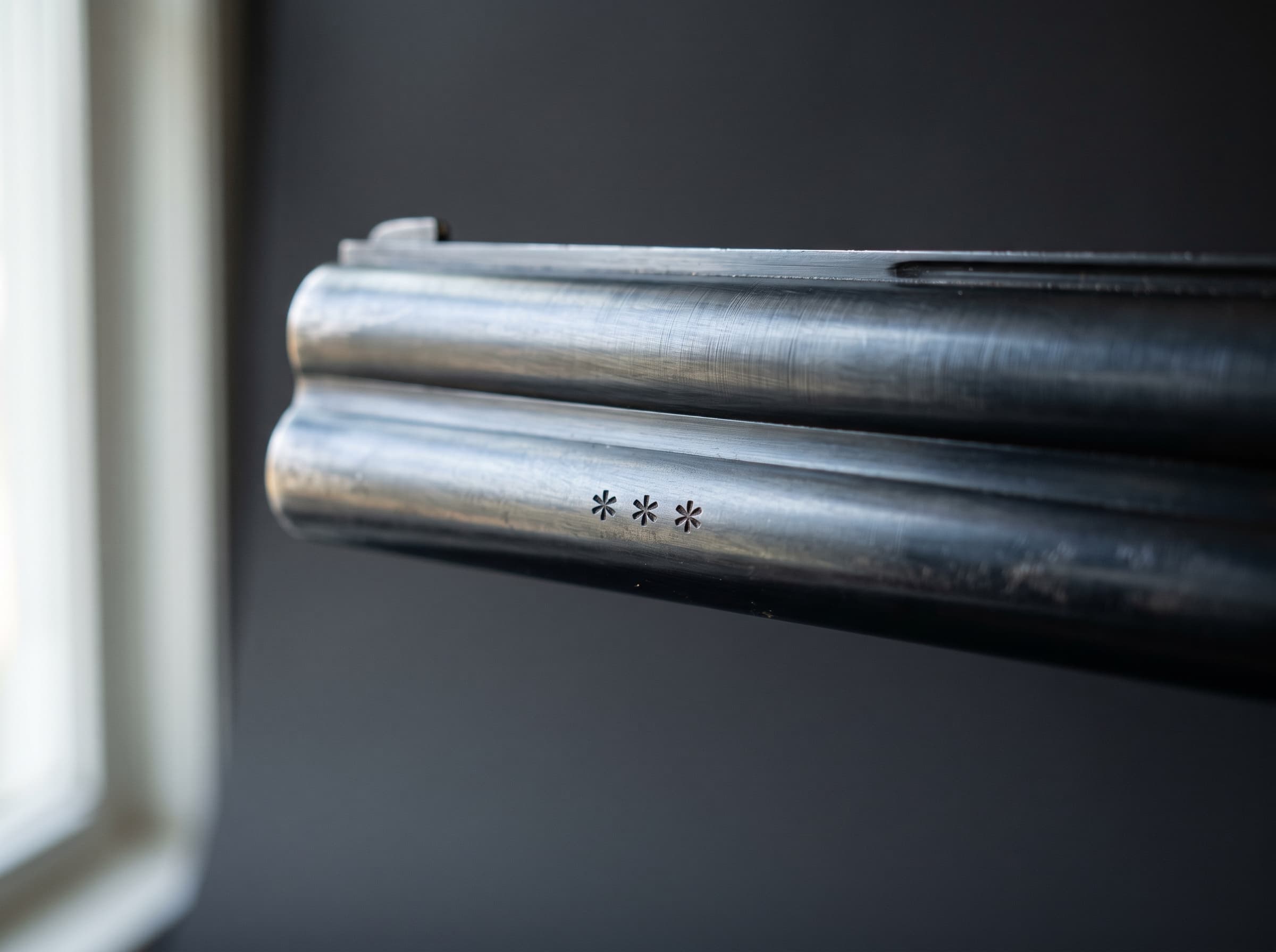 Over-under shotgun barrels with three Italian-style choke stars stamped near the muzzle