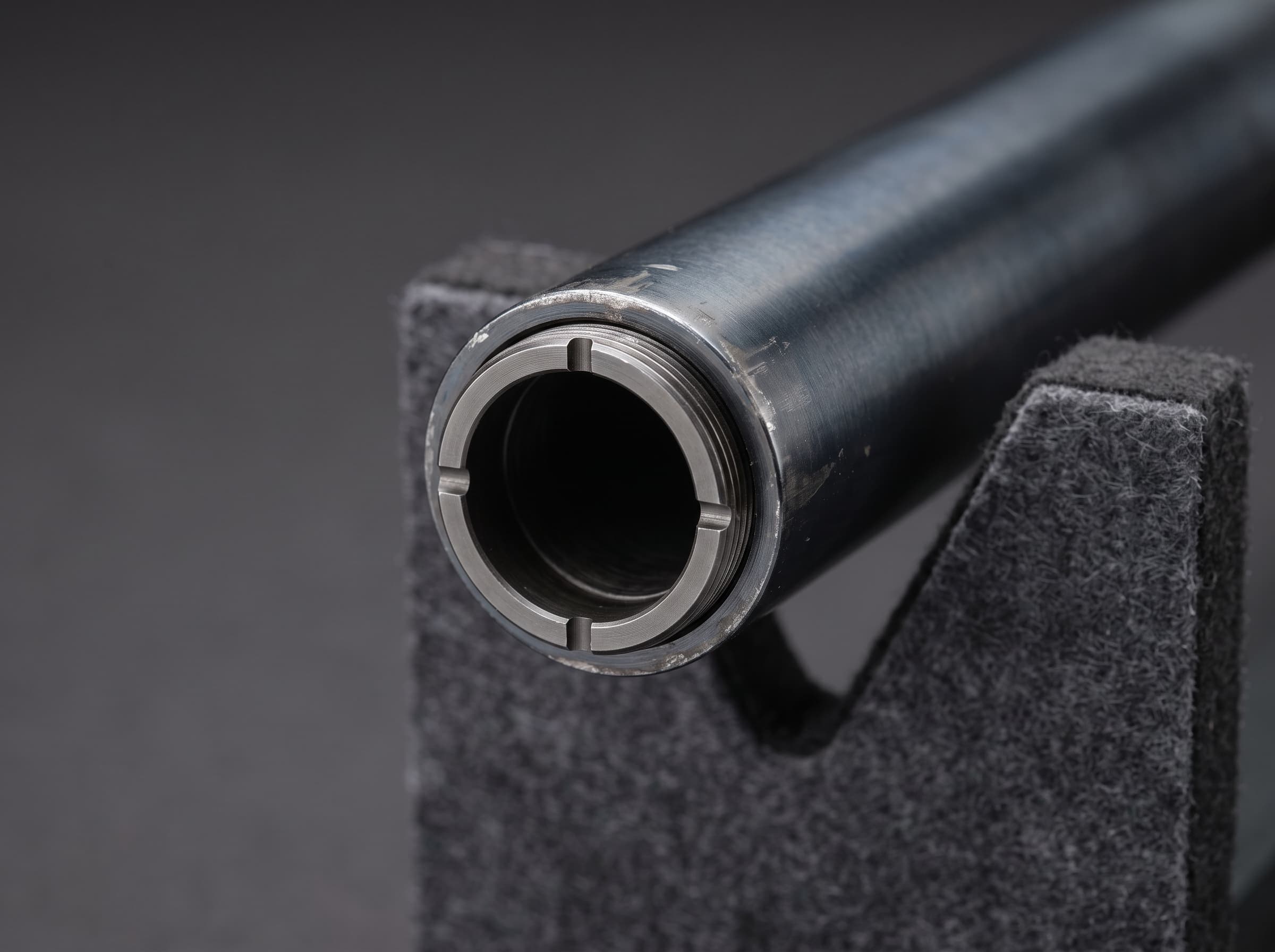 Flush choke tube installed in a shotgun muzzle with four identification notches on the rim